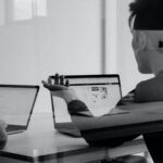 Two people having a conversation in front of their laptops